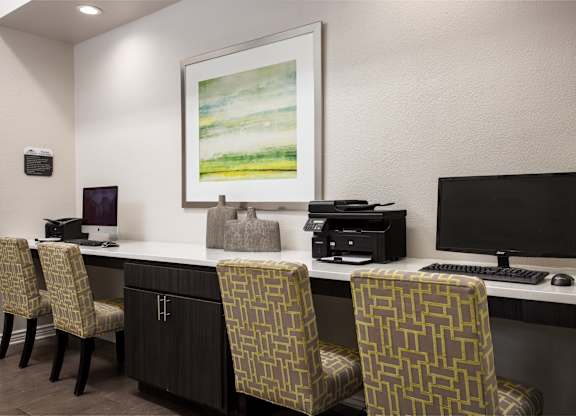 A room with a desk, chairs, and a monitor.