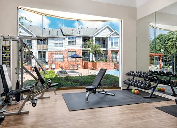 A gym with a view of a brick building across the street.