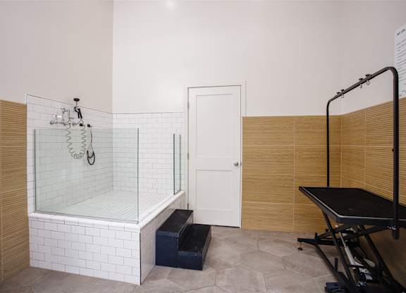 A bathroom with a glass shower stall and a bench.