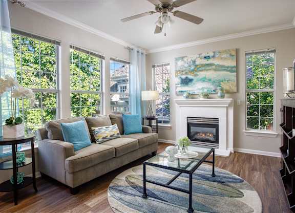 A living room with a couch, a fireplace, and a painting on the wall.