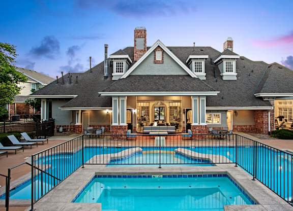 A house with a pool in front of it.
