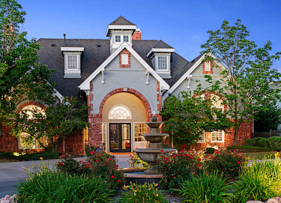 A house with a fountain in front of it.