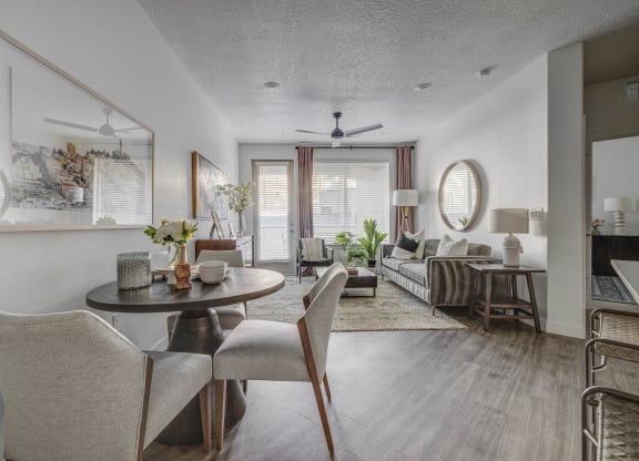 a living room and dining room with a table and chairs