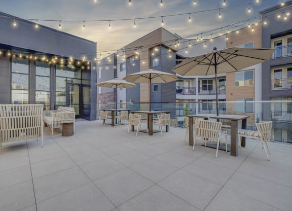 a patio with tables and chairs and umbrellas