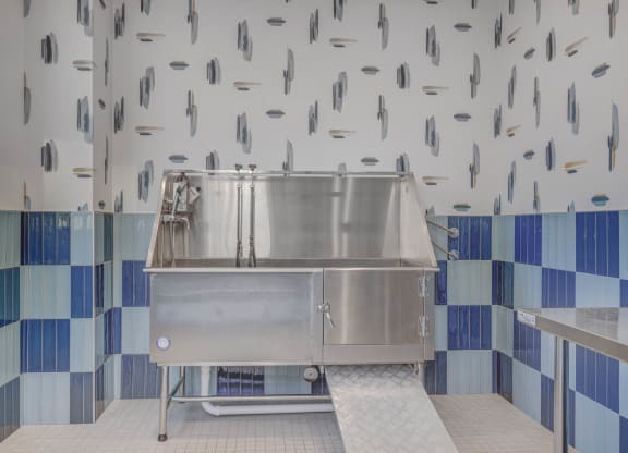 a large stainless steel sink in a kitchen with blue and white tiles