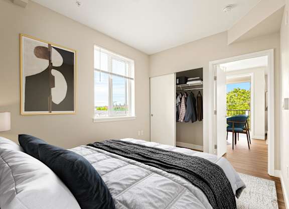 A bedroom with a large bed and a painting on the wall.