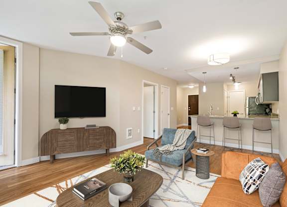 A living room with a television, a couch, a chair, and a coffee table.