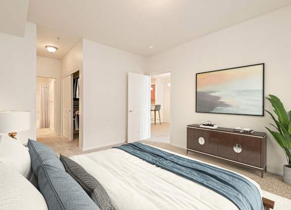A bedroom with a large bed and a painting on the wall.
