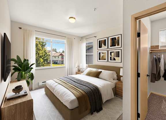 A bedroom with a large bed and a view of a house through the window.