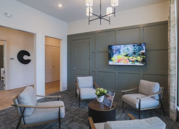 a living room with gray walls and a tv on the wall