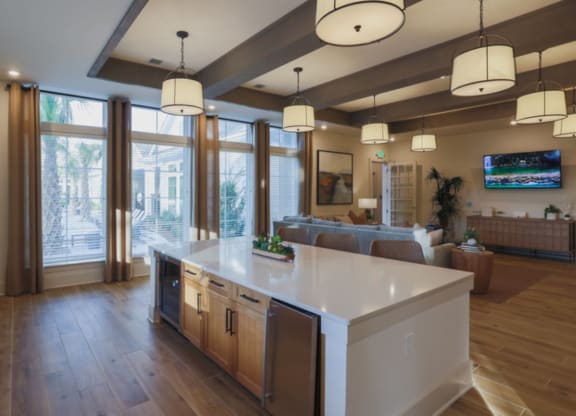 a kitchen with a large island in the middle of it and a living room in the background