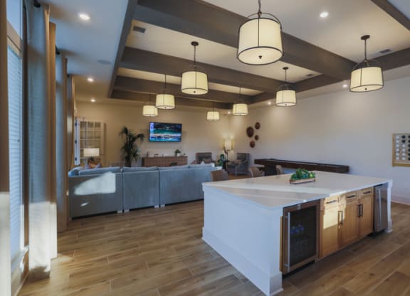 a kitchen with a center island and a living room in the background