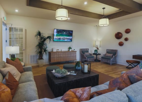 a living room with couches and a coffee table in front of a flat screen tv