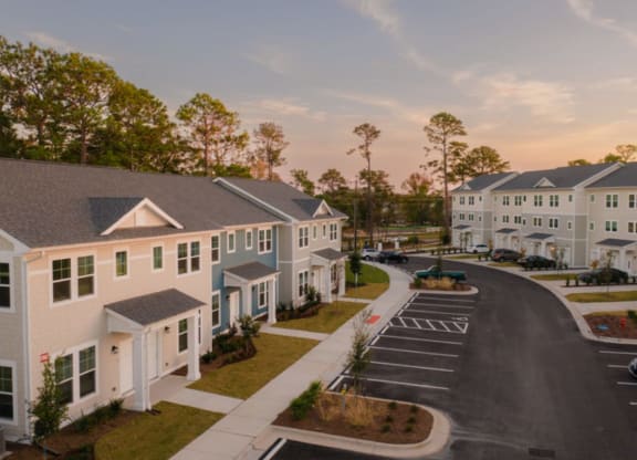 an aerial view of an apartment complex with a sunset in the background