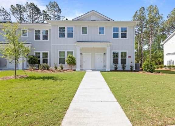 a large gray house with a white door