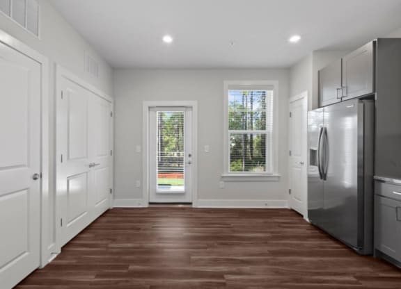 a kitchen with white cabinets and a stainless steel refrigerator