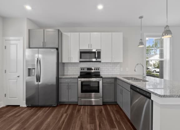 a kitchen with white cabinets and stainless steel appliances