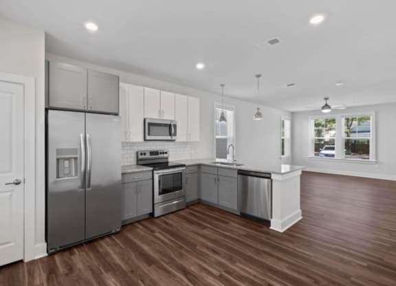 a kitchen with white cabinets and a wooden floor