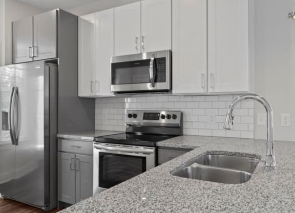 a kitchen with white cabinets and a granite counter top