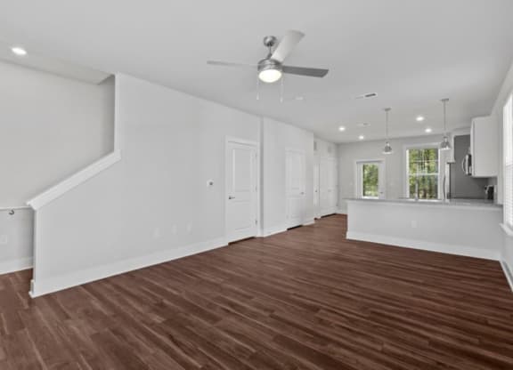 a living room with white walls and a ceiling fan