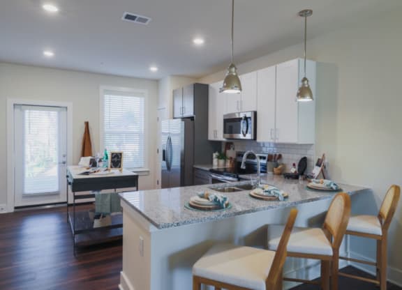 a kitchen with white cabinets and a granite counter top