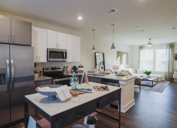 a kitchen with a large island and a living room in the background