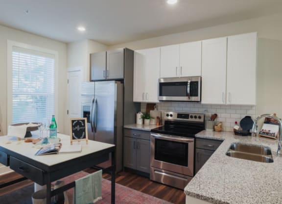 a kitchen with white cabinets and stainless steel appliances