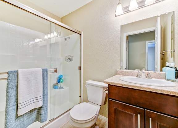 A bathroom with a toilet, sink, and shower.