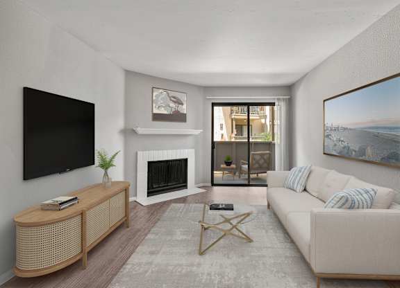 A living room with a white couch, a fireplace, and a painting on the wall.