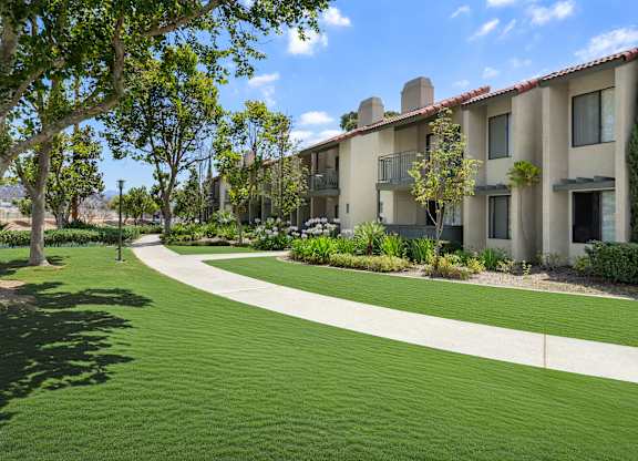 A grassy area in front of apartment buildings.
