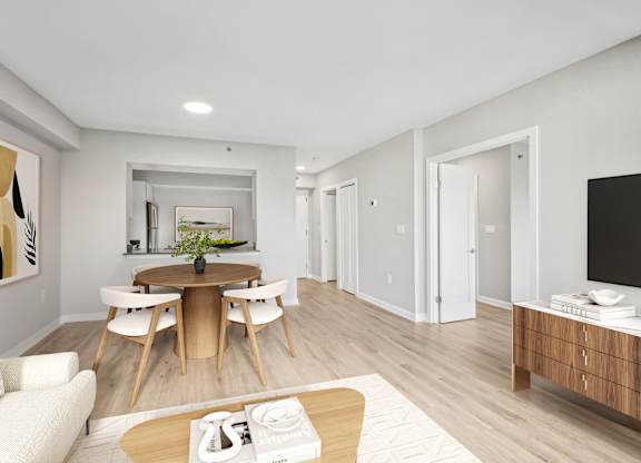 a living room and dining room with a table and chairs