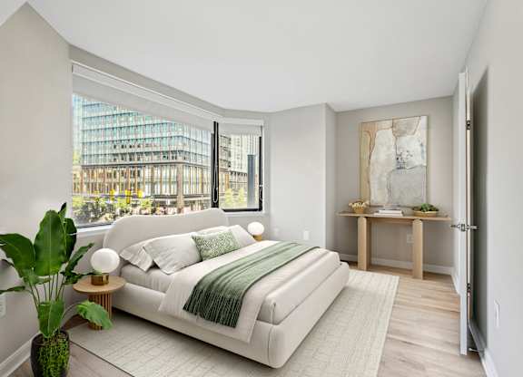 a bedroom with a white bed and a large window