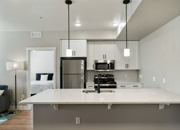 a kitchen with a large island and a stainless steel refrigerator