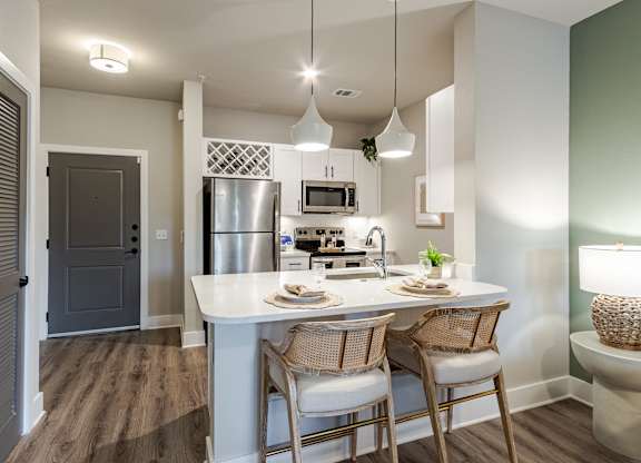 A kitchen with a table and chairs.