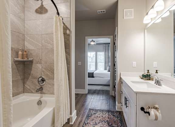 A bathroom with a white tub and a white sink.
