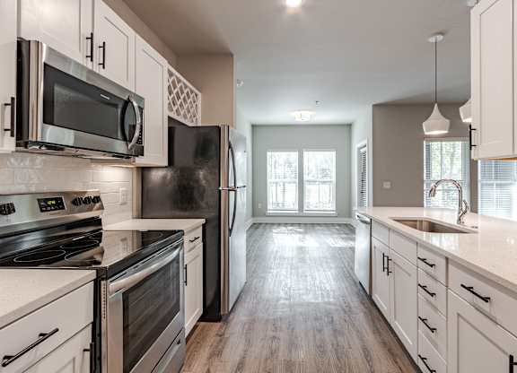A kitchen with black appliances and white cabinets.