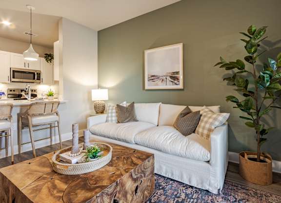 A living room with a white couch and a wooden coffee table.