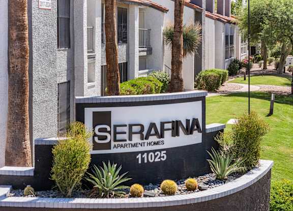 A sign for Serafina Apartment Homes is in front of a building.