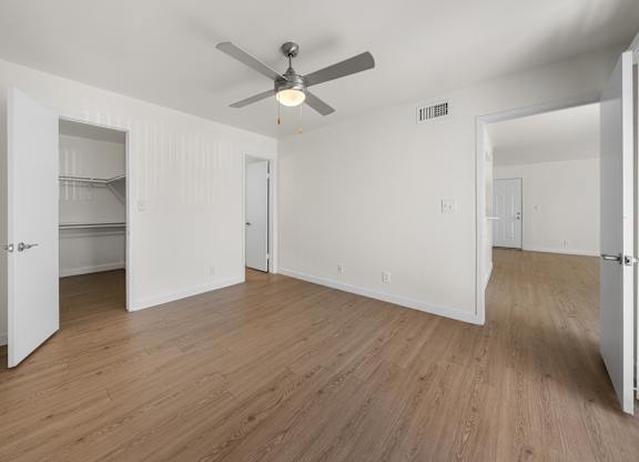 Empty room with a ceiling fan and light fixture.