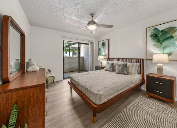 A bedroom with a bed, dresser, and mirror.