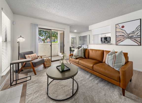 A living room with a brown couch and a coffee table.