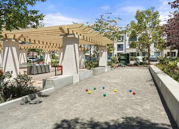 A playground with a wooden pergola and concrete ground.