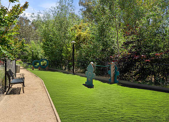 A park with a bench and a green lawn.