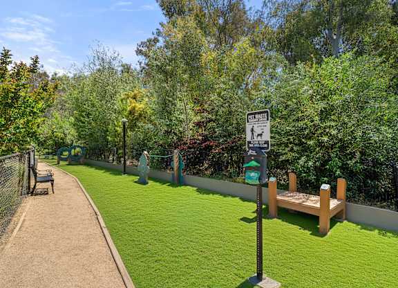 A sign in a park indicates a dog walking area.