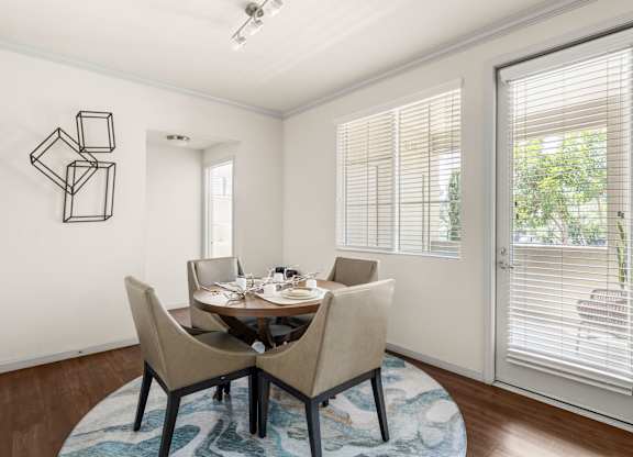 A dining room with a table set for two and a wall art.