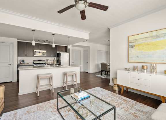 A modern kitchen with a bar area and a living room with a sofa.