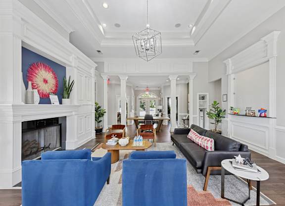 A living room with a fireplace and blue chairs.