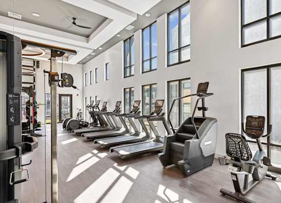 A gym with treadmills, elliptical machines, and other exercise equipment.