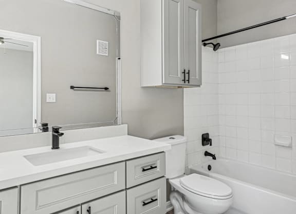 A white bathroom with a sink, toilet, and bathtub at Clear Creek Meadows Apartments, Apartments, Copperas Cove, TX