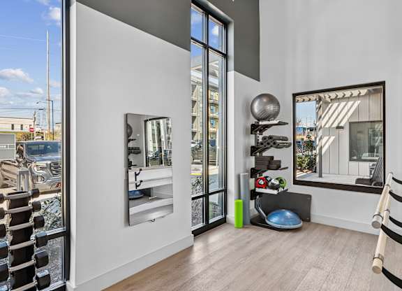 A room with a mirror, a ball, and a bench.